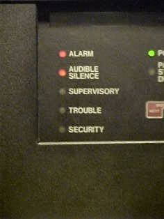 Meanwhile, above the annunciator up on the alarm panel (FACP), it's showing the same alarm condition existing, and since the alarm was at this point unacknowledged by us, both the "alarm" and "audible silence" lights were flashing. When the system receives an acknowledgement to the alarm, the "alarm" light stops flashing and stays solid, and when the audible silence button is pressed, that kills the sound, and the "audible silence" light stops flashing and stays on.