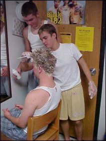 While Jackson holds the bottle, Patrick gets the stuff where it needs to be, while Joe looks on through the mirror.