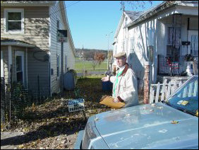 Behind the no-parking sign, and what Mr. Sullivan is gesturing towards, is what is described as a "paper alley", so called because it's technically a public alley, but only on paper, as this is definitely not a public alley in practice. In fact, this public alley has a horseshoe pit in it.