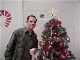 Andrew takes a second to pose with the Christmas tree for the camera.