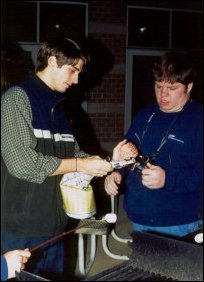 Here I am attempting to help someone light up an old issue of The Breeze in order to get the grill going.