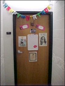 This door contains signs and a festive "Happy Birthday" banner across it. You can see a close-up of the sign on the left part of the door below.