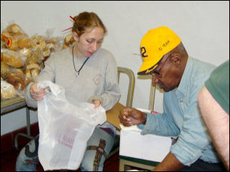 Mary helps double up the bags for the food pantry.