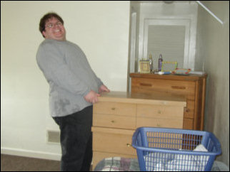 At Sojourner House, armed with Rug Doctor machines, we cleaned carpets. But before you can clean the rugs, you have to move the furniture off of it. Here, I'm having a time moving a dresser across the room.