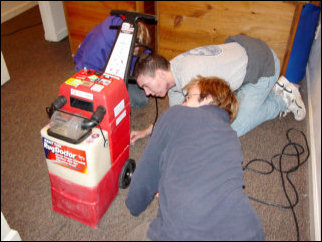 One of the Rug Doctor machines broke down on us! Here, Nicole, Mark, and Spencer take a look at it to try and figure out what was wrong with it. Turned out that it was nothing we could fix on the spot, but thankfully we had a backup, as Kathleen had her own Bissell steam cleaner. We used that.